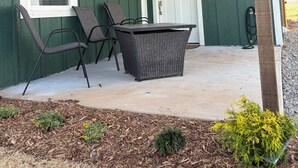 Un porche abrité, doté d’un ventilateur de plafond, d’une table et de deux chaises.