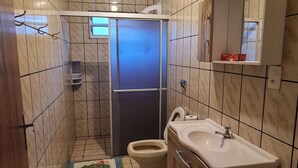 A bathroom with a toilet, sink, and mirror. - Entire house 350m from Ingleses Beach, sleeps up to 5 people. (Florianópolis)