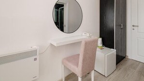 A room with a white desk, a pink chair, a black wardrobe, a white door, and a round mirror on the wall. - Azzurro Hotel Bijela, Herceg Novi (Bijela)