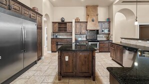 Una cucina con isola centrale, elettrodomestici integrati e mobili in legno.