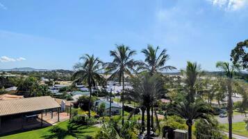 Zona residencial con piscina, palmeras y casas.