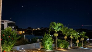 A residential area at night with houses, palm trees, and a well-lit street. - Lumina Motel (South Gladstone)