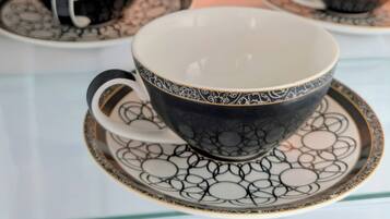 Una pila de tazas y platillos blancos y negros con un diseño.