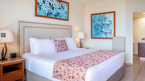 Ein Hotelzimmer mit einem Bett, zwei Wandleuchten, einem Nachttisch und zwei gerahmten Kunstwerken.