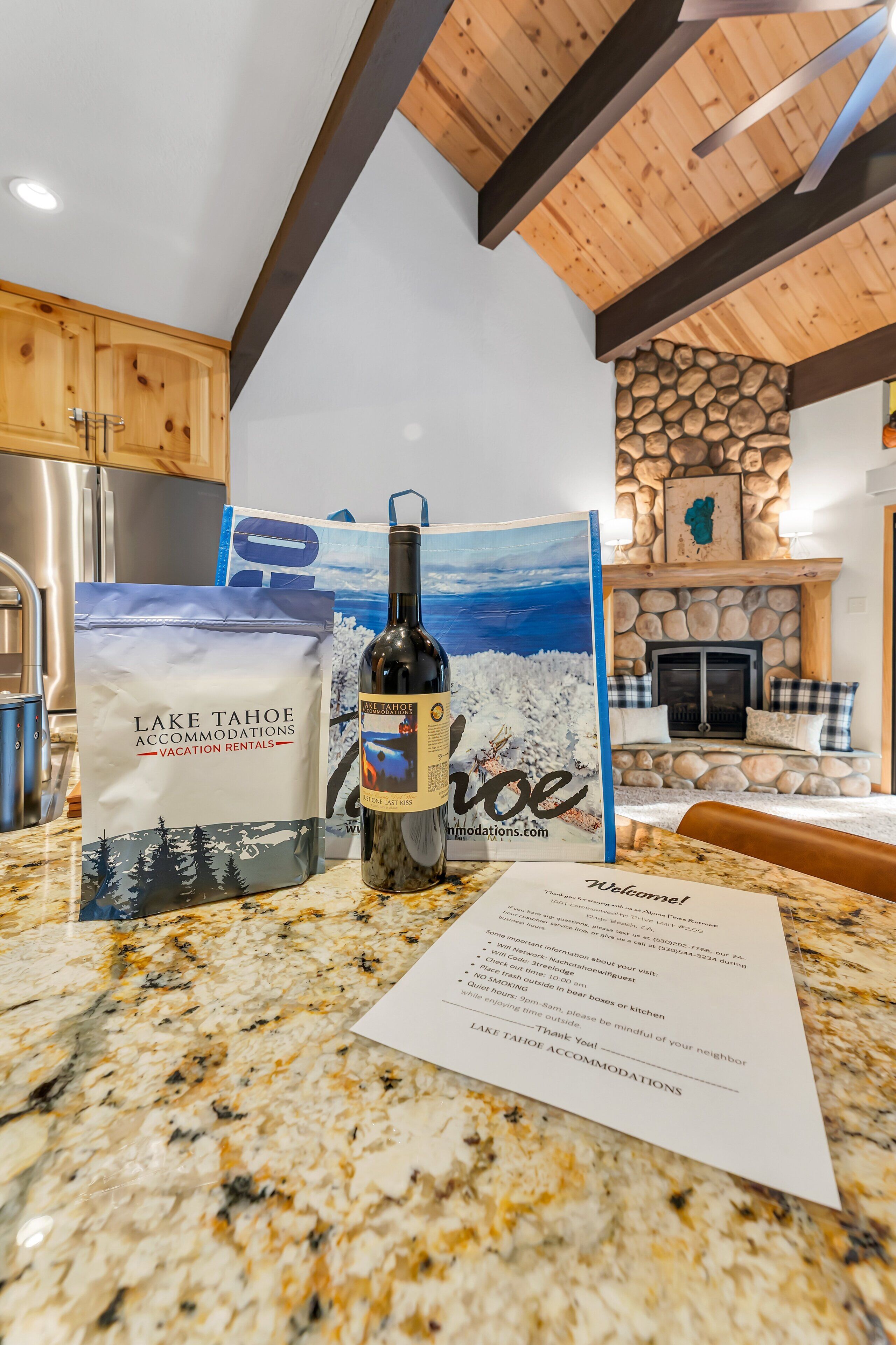 A kitchen counter with a wine bottle, a bag of Lake Tahoe accommodations vacation rentals, and a welcome sign.
