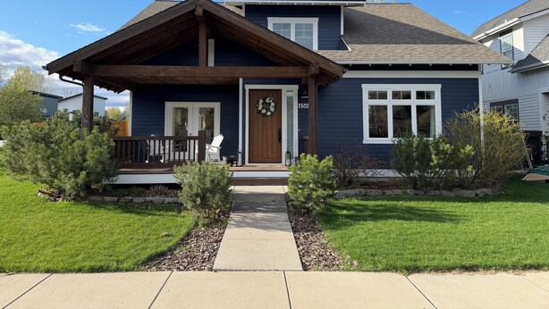 A two-story house with a front porch, a door with a wreath, and a number '456' on the wall. - The Blue House: Spacious home w/ patio, fenced yard, views, close to everything (Bozeman)