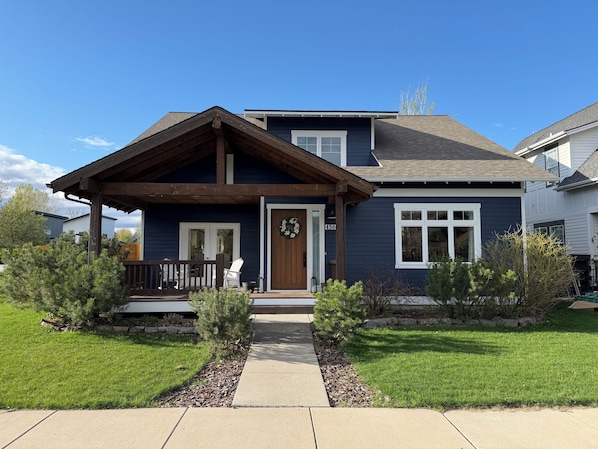 A two-story house with a front porch, a door with a wreath, and a number '456' on the wall.