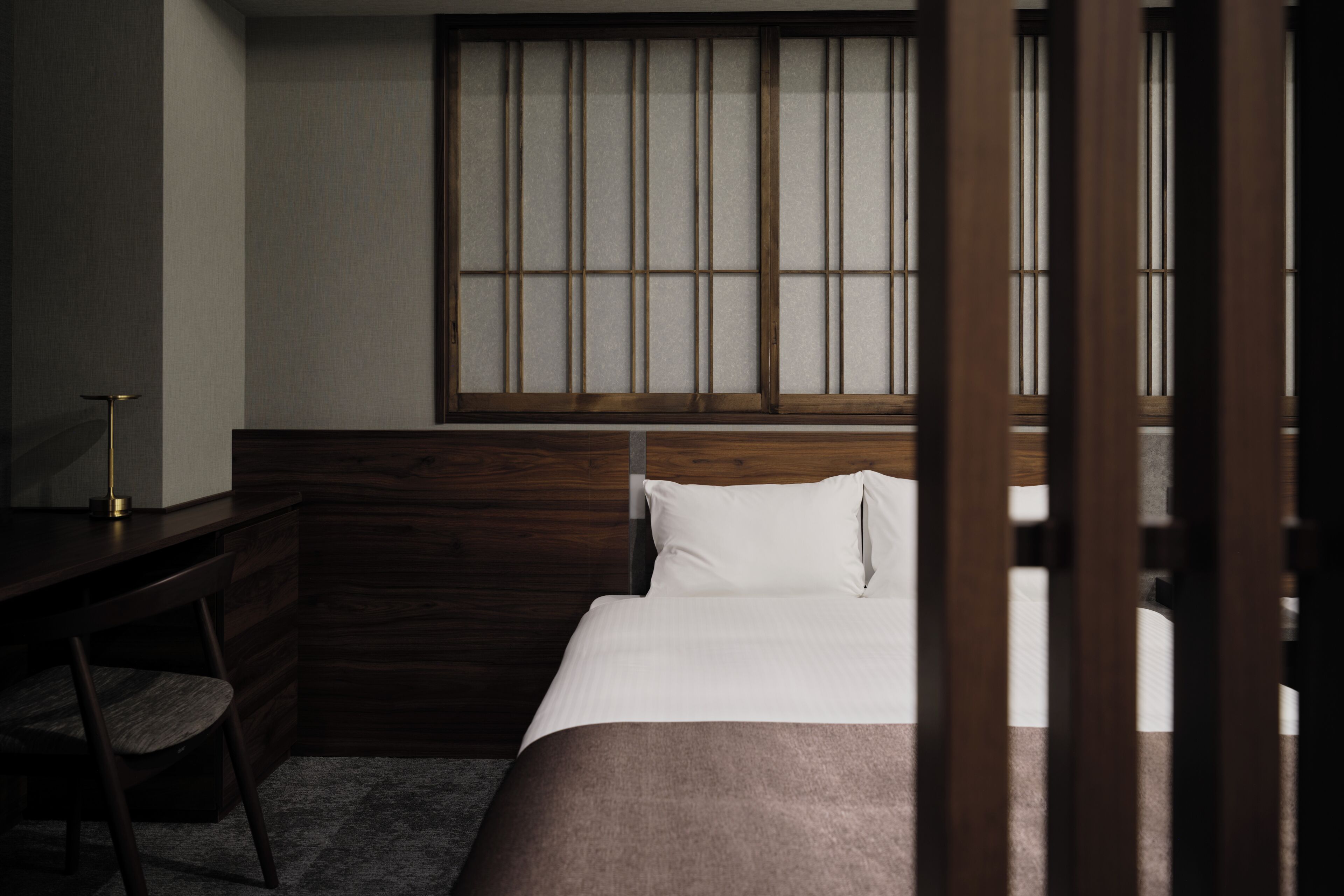 Un dormitorio con cabecera de madera, un escritorio y una silla.