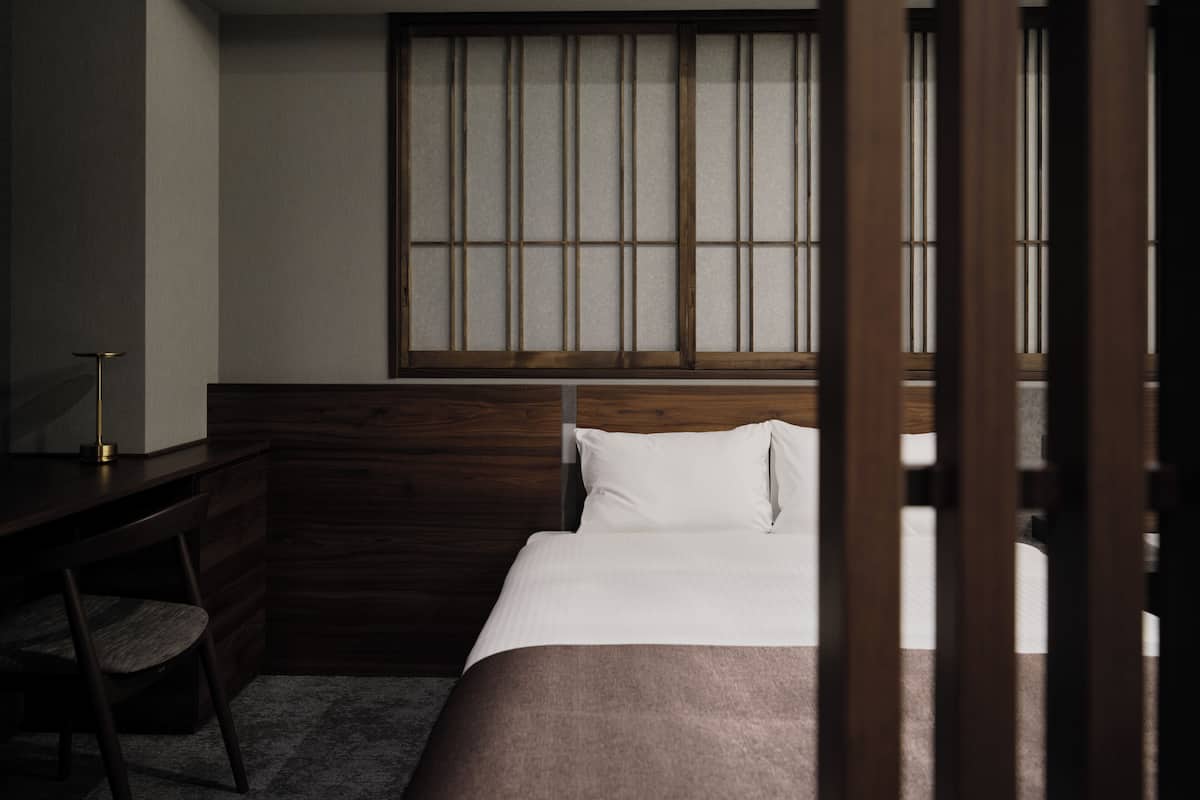 Un dormitorio con cabecera de madera, un escritorio y una silla.