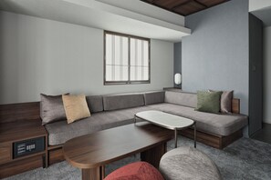 A modern living room with a sectional sofa, a coffee table, and a built-in entertainment unit. - Premium MONday ASAKUSA I (Tokyo)