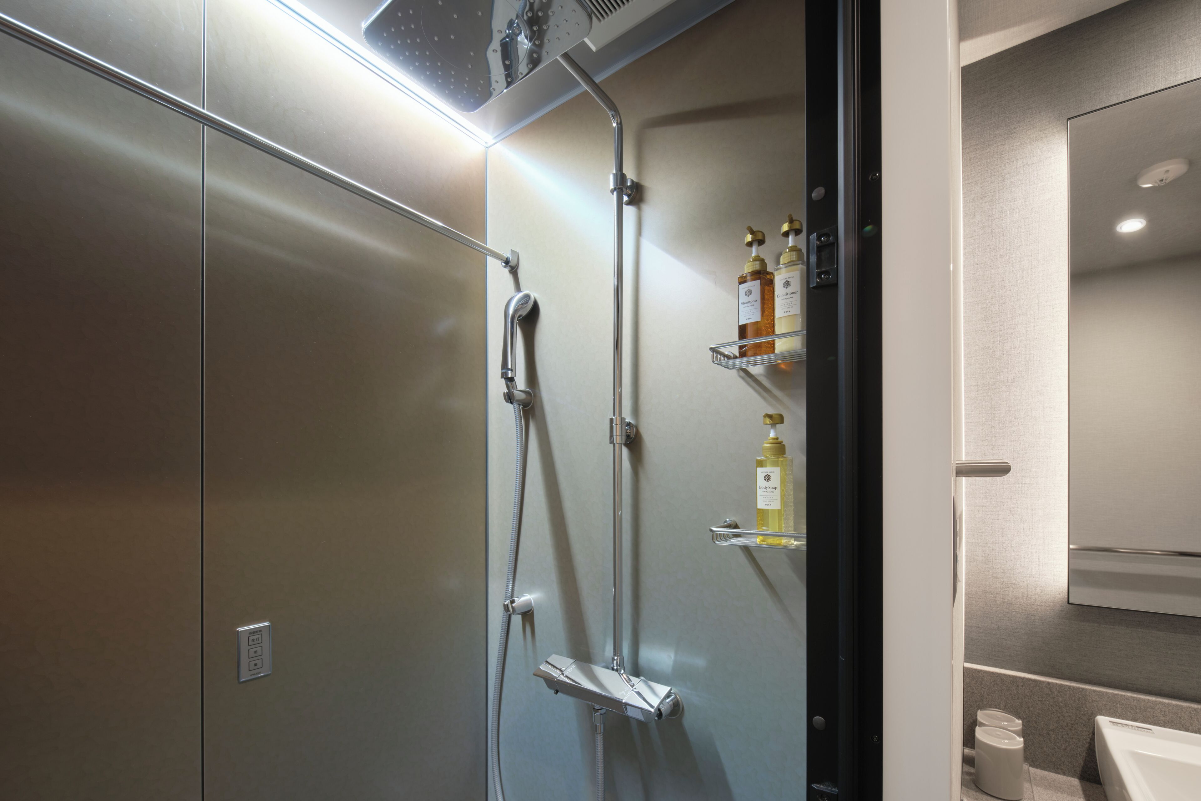 Een moderne badkamer met een douche, toilet en wastafel.