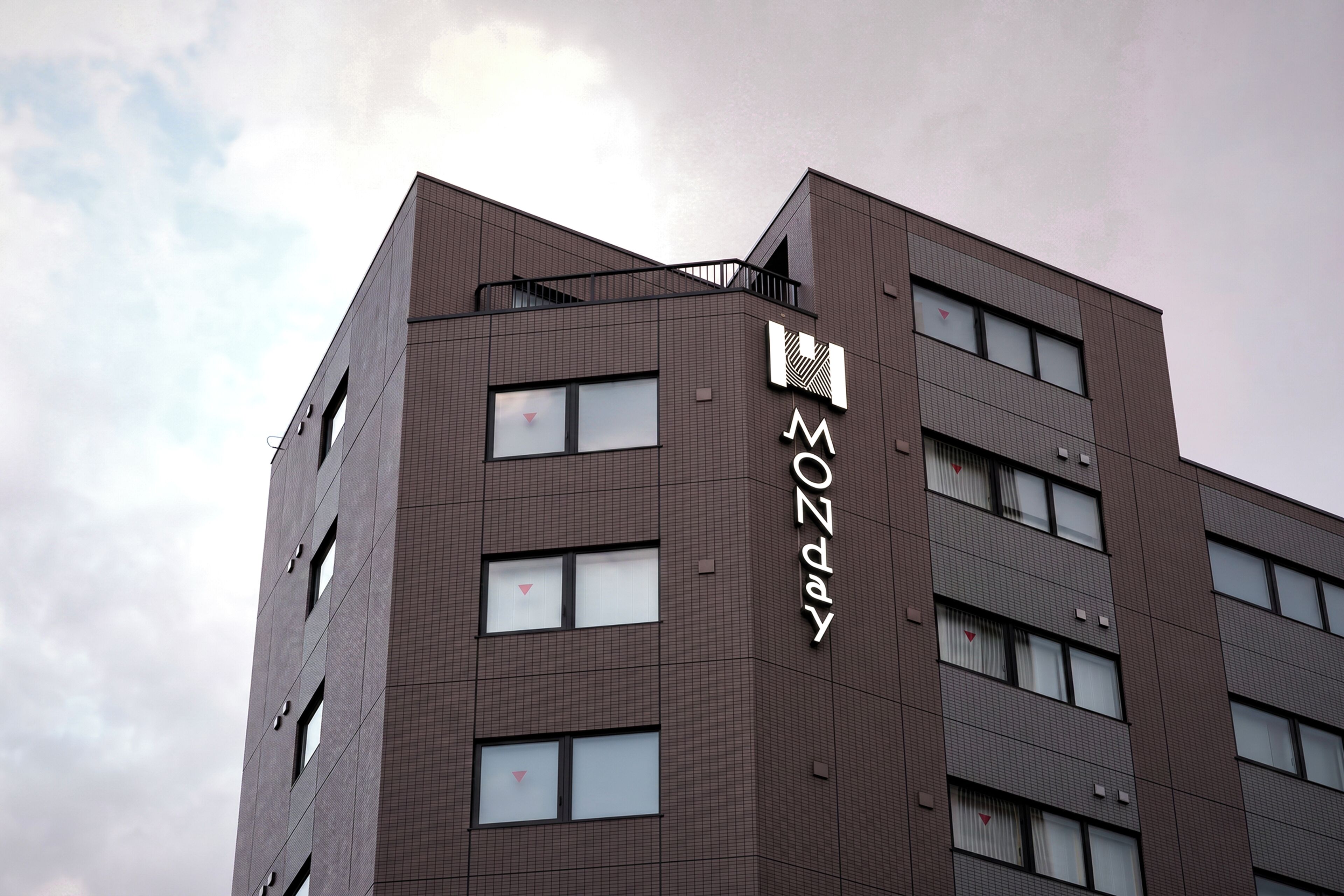 A modern building with a prominent 'MONDAY' sign on the side.