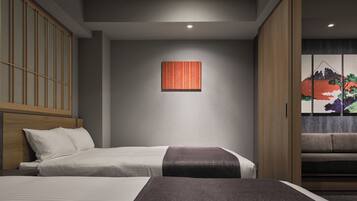 A hotel room with two beds, a wooden wardrobe, a wall-mounted artwork, and a sliding door with a view of a mountain.