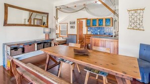 Une cuisine rustique avec des meubles en bois, une grande table en bois et une chaise bleue.