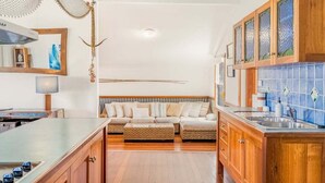 Une cuisine moderne avec des meubles en bois, une cuisinière encastrée et un dosseret de carrelage bleu.