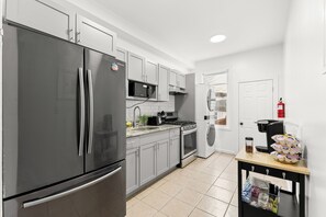 Uma cozinha moderna com eletrodomésticos de aço inoxidável, micro-ondas, forno e máquina de café.