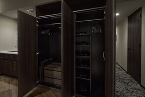 A walk-in closet with a mirrored closet door, shelves for shoes, and a hanging rack for clothes. - Premium hotel MONday MAIHAMA VIEW II (Tokyo)