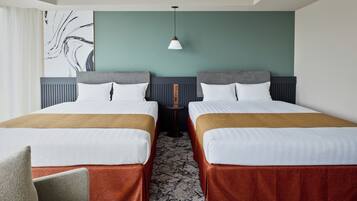 A hotel room with two beds, a wall-mounted artwork, a pendant light, and a patterned carpet.