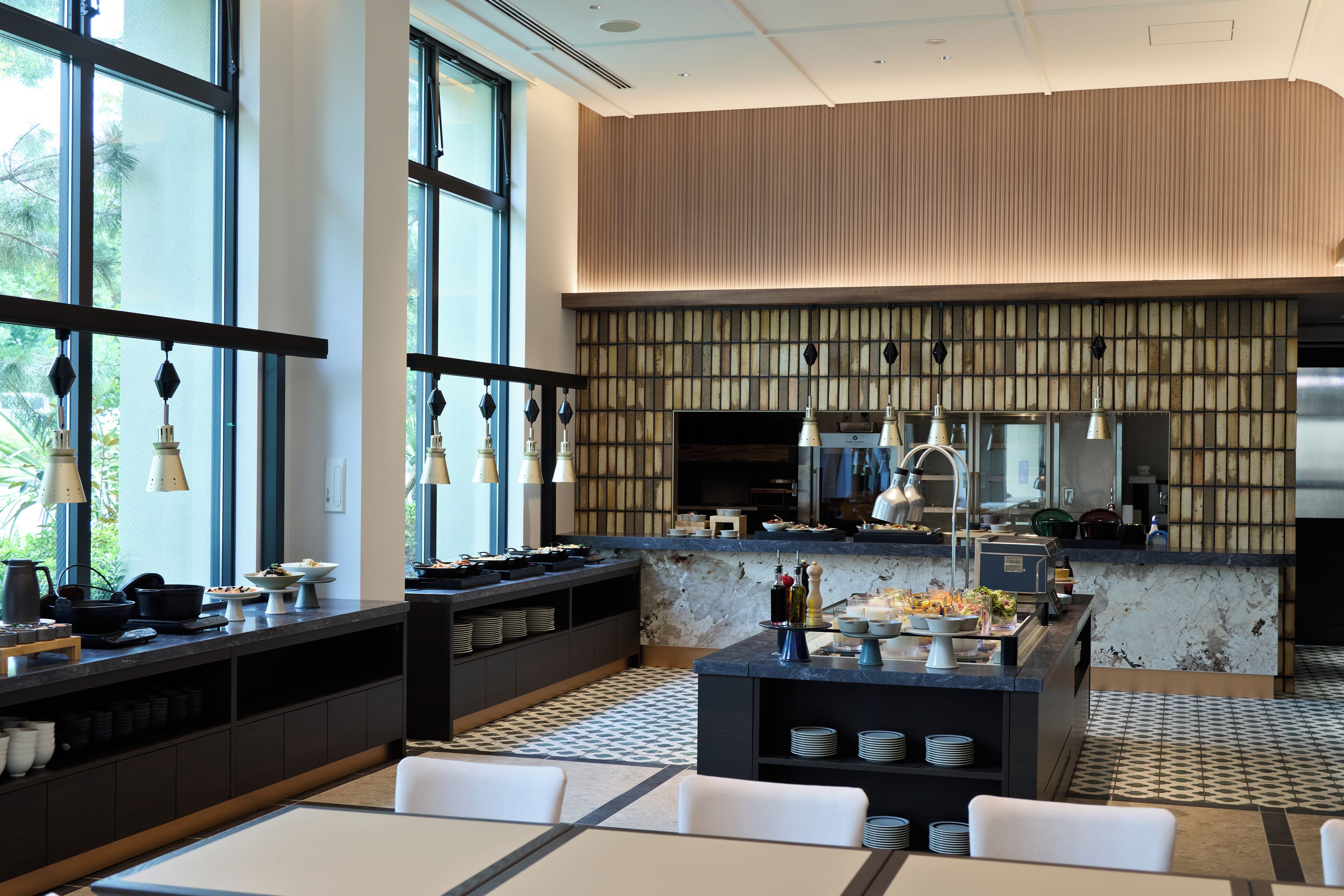 A modern restaurant interior with a bar area, seating, and a view of the outdoors.