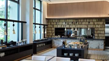 A modern restaurant interior with a bar area, seating, and a view of the outdoors.