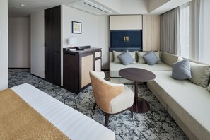 A hotel room with a bed, a sofa, a desk, and a chair. - Premium hotel MONday MAIHAMA VIEW II (Tokyo)