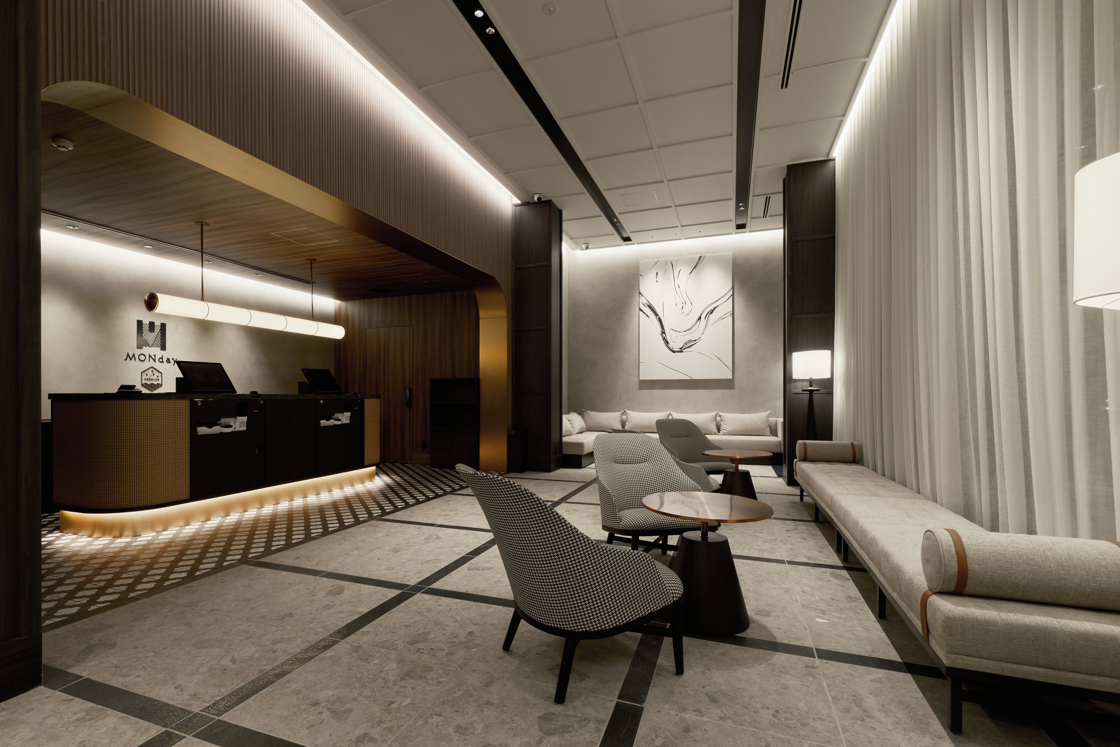 A modern lobby with a reception desk, seating area, and a large abstract artwork on the wall.