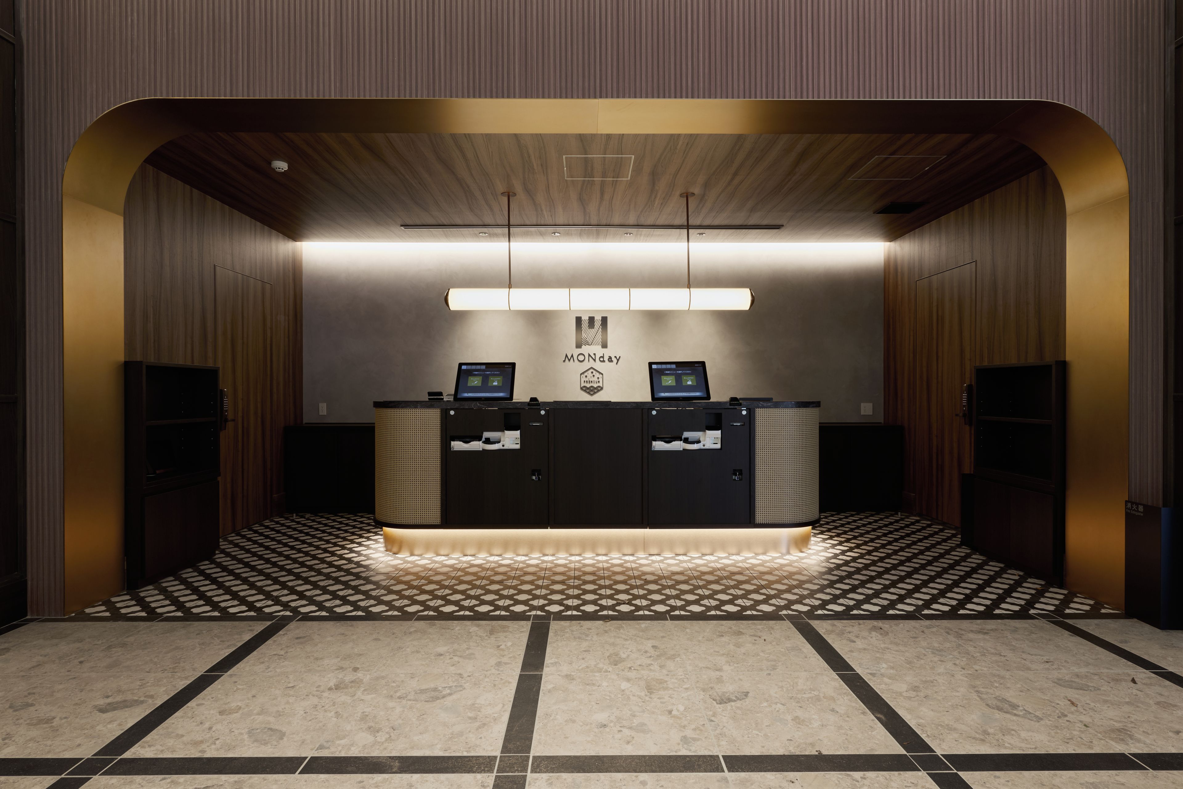 A reception desk with a modern design, a logo above it, and a patterned floor.
