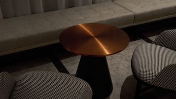A modern seating area with a round table and two patterned chairs.