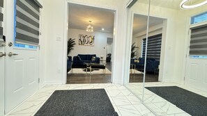 Un intérieur moderne avec un canapé bleu foncé, une table basse en verre et un luminaire décoratif.