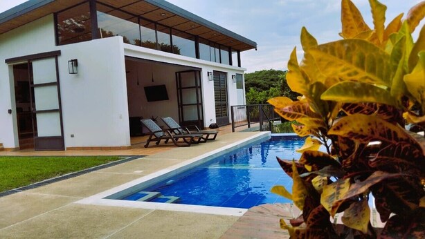 A modern house with a swimming pool, a covered patio, and a view of the surrounding greenery. - Casa Campestre San Joaquin La Mesa (La Mesa)