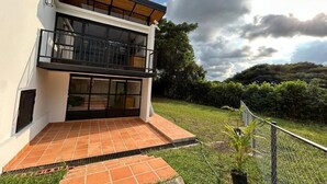 A modern two-story house with a balcony, a tiled patio, and a fenced yard. - Casa Campestre San Joaquin La Mesa (La Mesa)