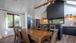 Une cuisine moderne dotée d’un îlot central, d’une table à manger en bois et de chaises.