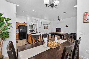 A modern kitchen with a black refrigerator, wooden cabinets, and a central island. - Pickleball | 6 Min to Cardinals | DT PHX 25 Min (Glendale)