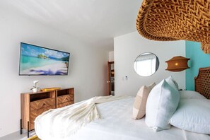 Ein Schlafzimmer mit einem Bett, einem Holzschrank, einem Fernseher, einem Spiegel und einer gewobenen Leuchte.