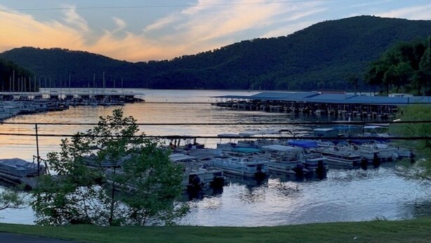 A marina with boats docked, a dock extending into the water, and a hilly landscape in the background. - Private 16-Acre Escape w/ Creek • Peaceful & Quiet • Fire Pit, Hiking & Lake (Hampton)