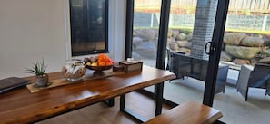 A wooden table with a bowl of fruit, a small plant, and a tissue box. - SAKURA LODGE in Daylesford Victoria (Daylesford)