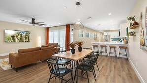A modern living room with a sofa, dining table, chairs, and a ceiling fan. - New Downtown Chandler | Family & Pet-Friendly (Chandler)