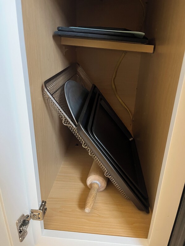 A storage space with a metal rack, a black object, and a wooden handle. - Downtown Hamilton Retreat - Walk to Dining + Sleeps 5+ (Hamilton)