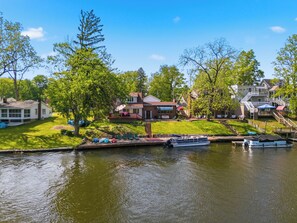 Zona residencial junto al lago con casas, un muelle y barcos.