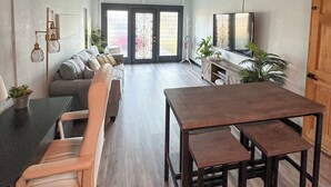 Een moderne woonkamer met een bank, een eettafel en een televisie.