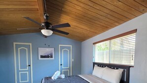 A bedroom with a bed, a ceiling fan, a window with blinds, and a door. - Wi-fi / Pool / Ac / Parking / Patio / Grill /Workspace / Ice Chest. (Bakersfield)