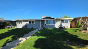 A residential house with a front yard, a pathway leading to the front door, and a small garden area. - Wi-fi / Pool / Ac / Parking / Patio / Grill /Workspace / Ice Chest. (Bakersfield)