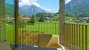 Un balcon avec vue sur une montagne et un village.