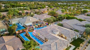 Zona residencial amb diverses cases, una piscina i un paisatge de muntanyes al fons.