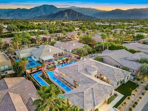 A residential area with multiple houses, a swimming pool, and a mountainous backdrop. - Sandbar/Lazy River/150K Gameroom (Indio)