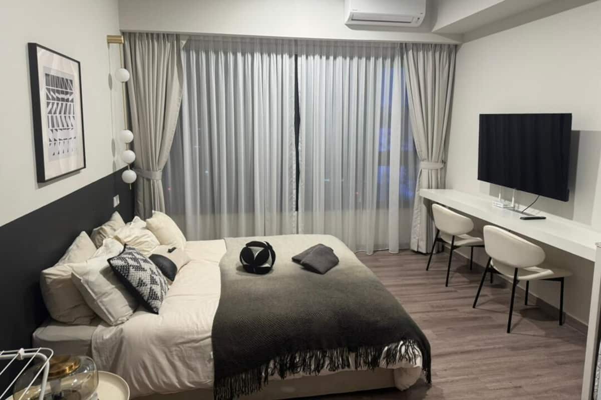 Ein modernes Hotelzimmer mit einem Bett, einem Schreibtisch und einem Fernseher.