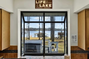 A view through a glass door with a sign above stating 'Life is better at the lake.'