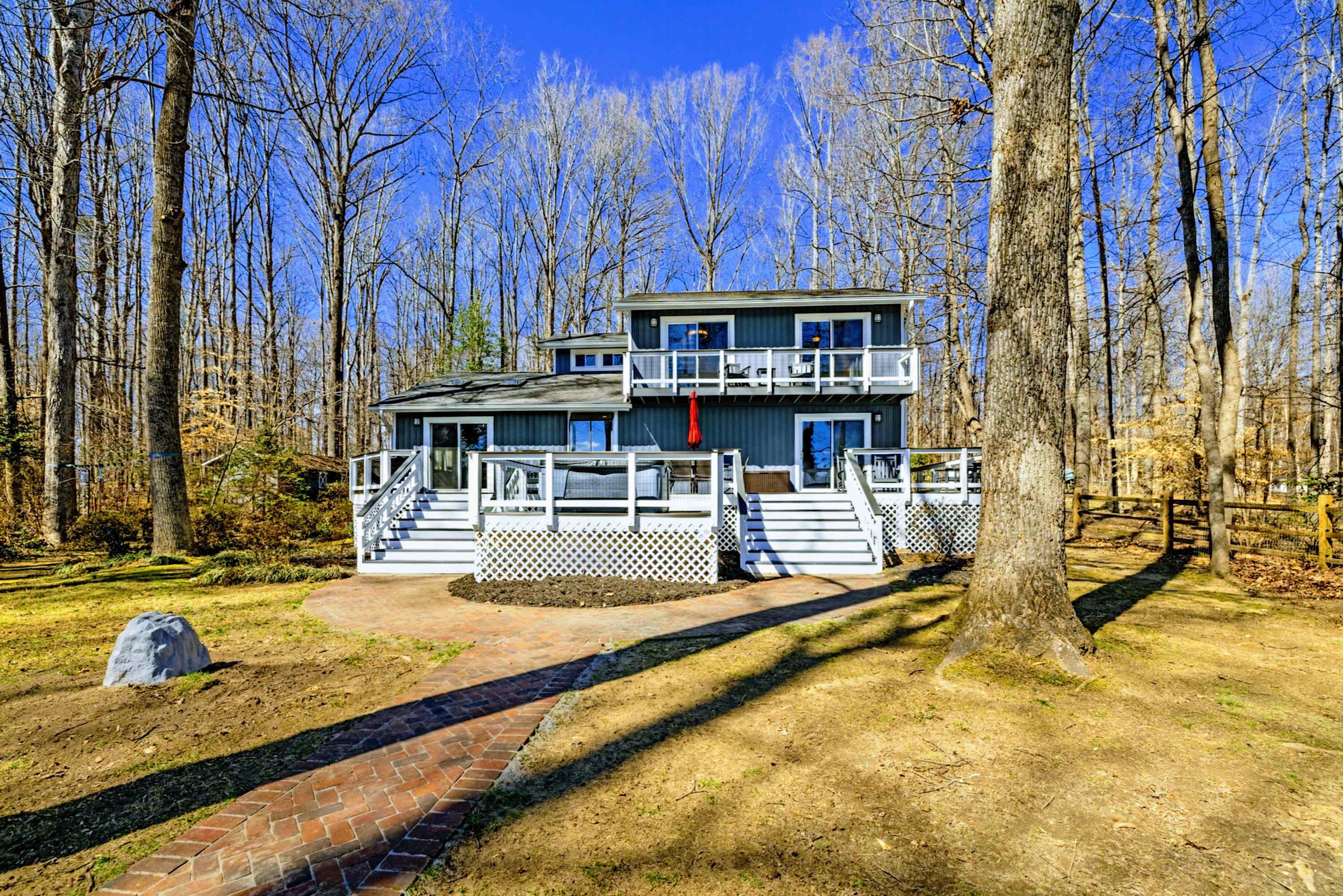 A two-story building with a balcony, surrounded by trees.