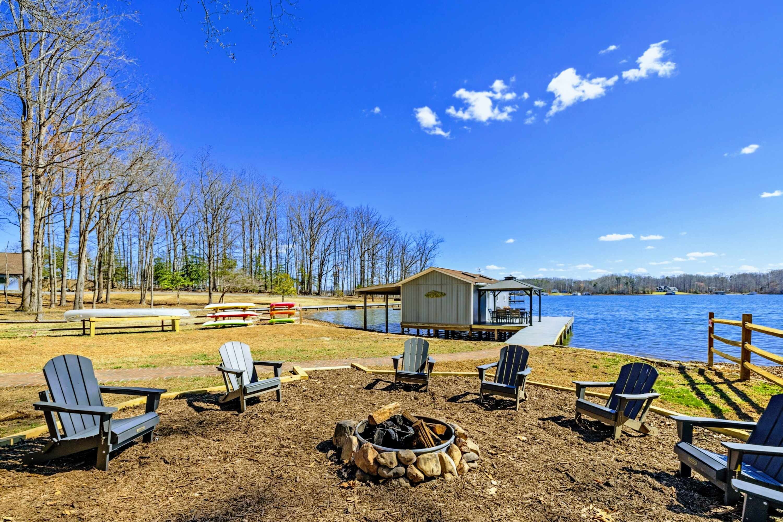 Lakeside Fire Pit - A circle of Adirondack chairs surrounds the fire pit overlooking the lake, with the boathouse and dock just steps away.