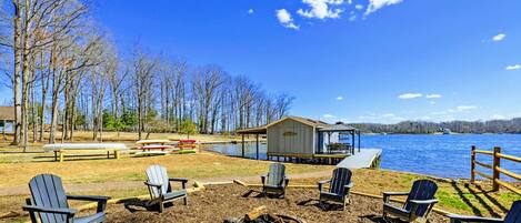 Lakeside Fire Pit - A circle of Adirondack chairs surrounds the fire pit overlooking the lake, with the boathouse and dock just steps away.
